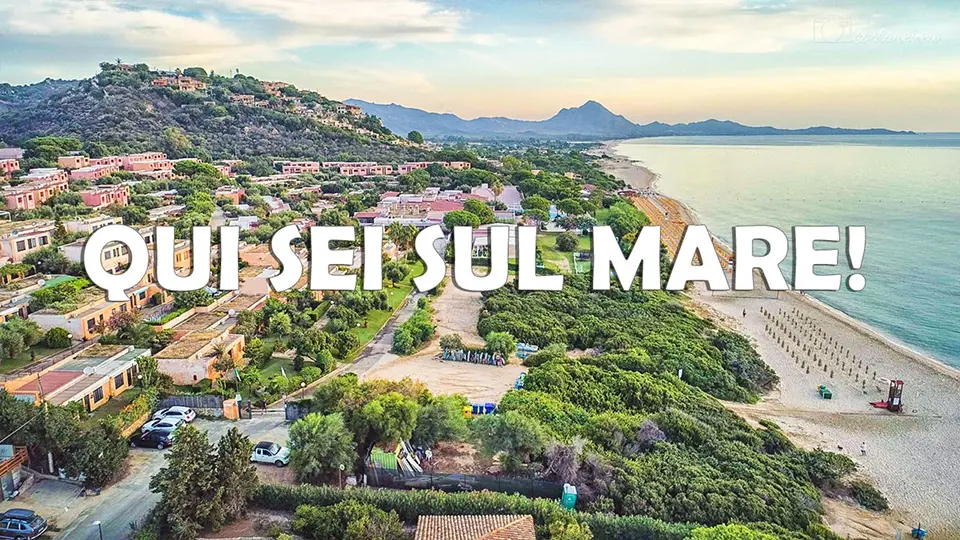 Vista aerea del Free Beach Residence e della spiaggia di Costa Rei con la scritta Qui sei sul mare